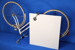Ein umgedrehtes Fahrrad steht da, Kette und Zahnräder sind von einer weißen Platte verdeckt.